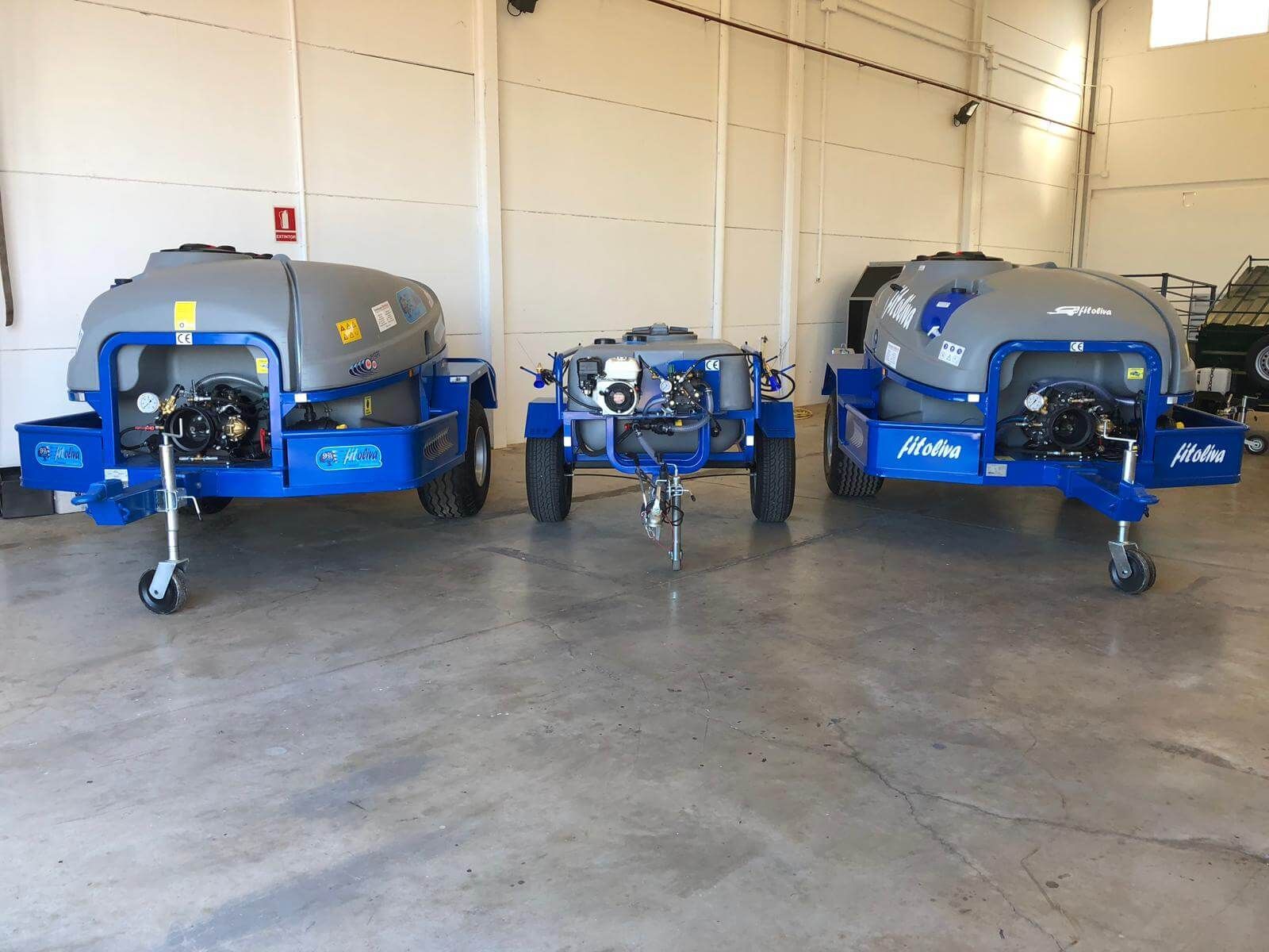 Tres remolques de tractor están estacionados en un almacén.