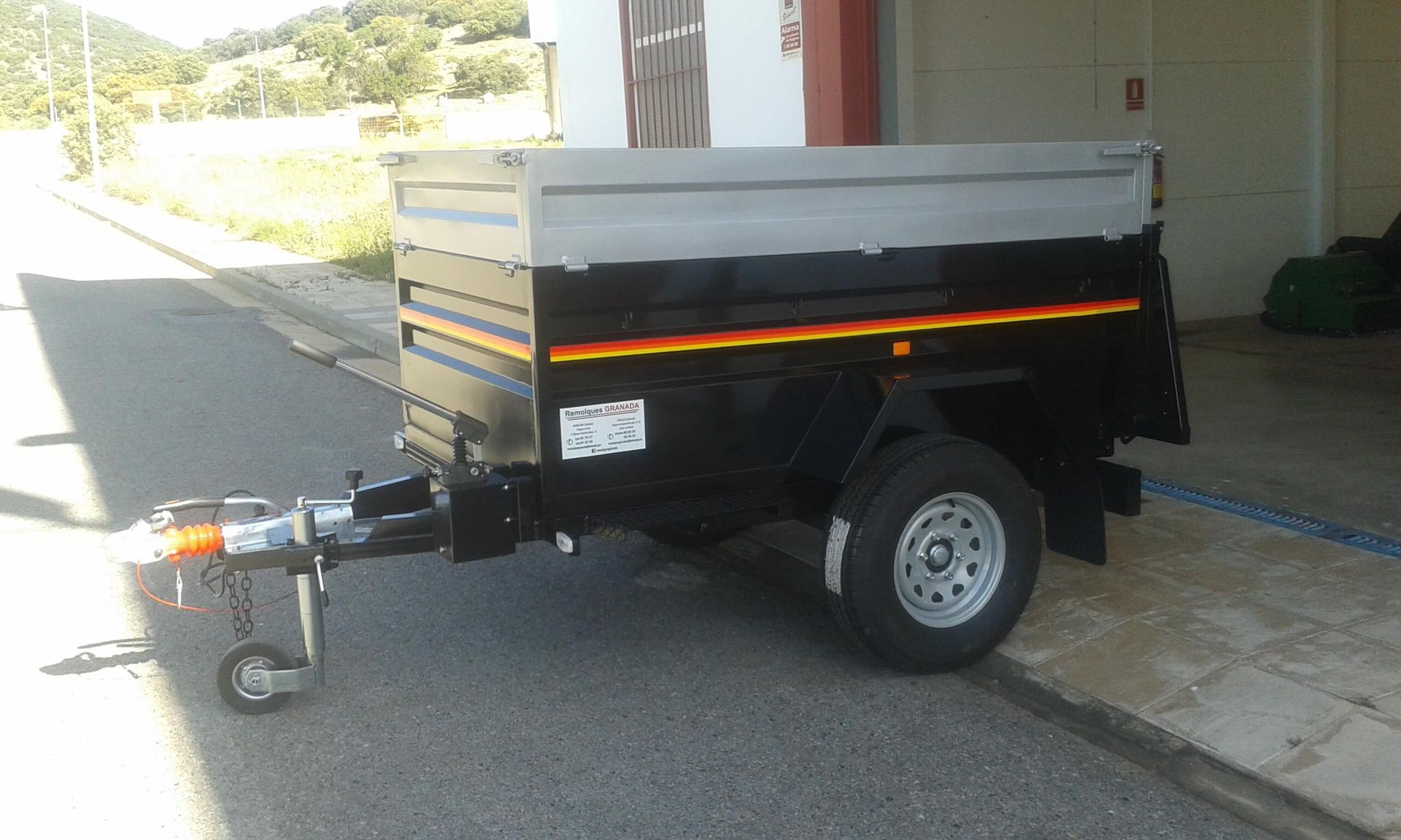 Un pequeño remolque está estacionado al costado de la carretera.