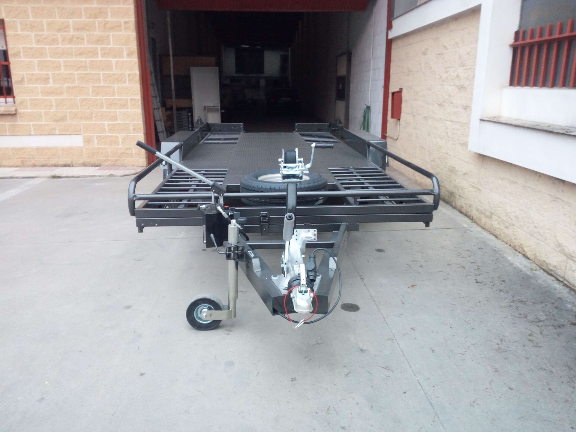 Un remolque está estacionado frente a un edificio de ladrillos.