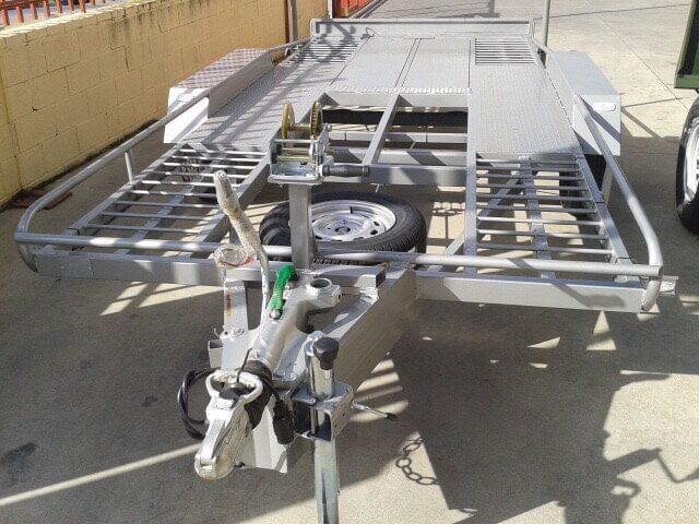 Un remolque de motocicleta está estacionado al costado de la carretera.