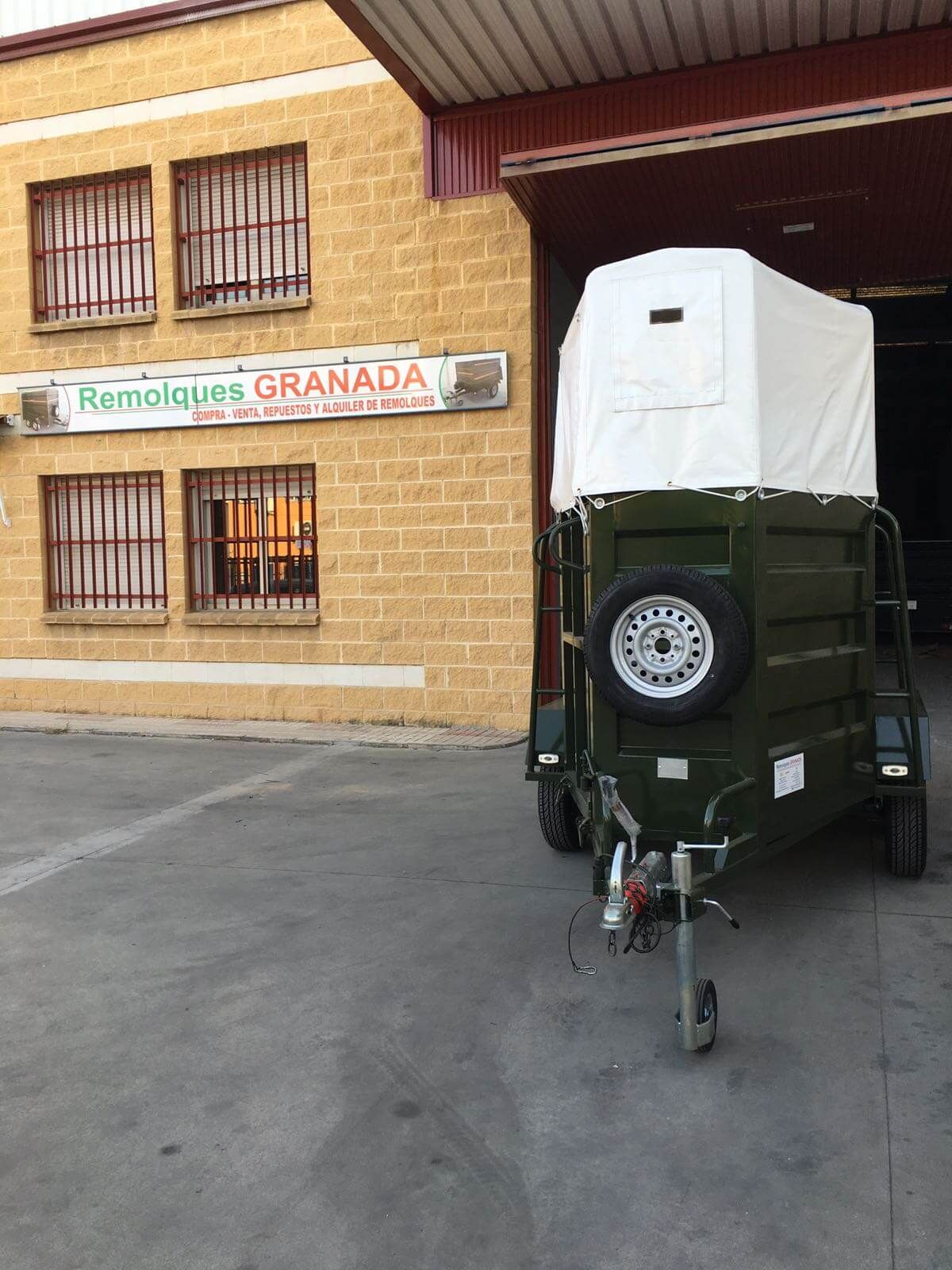 Un remolque está estacionado frente a un edificio que dice granada