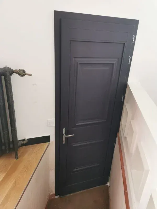 Porte d'entrée classique noire en bois prise en photo de l'intérieur