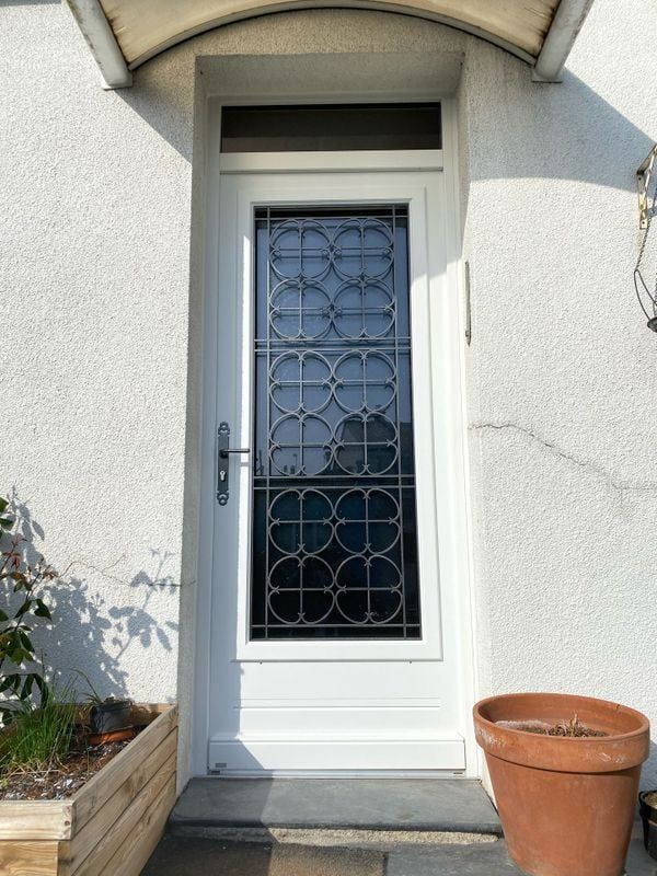Porte d'entrée avec une fenêtre et un décor en ferronerie