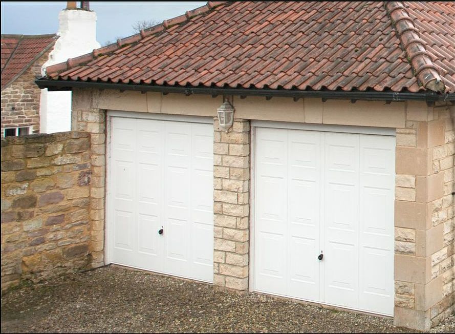 Façade d'une maison avec deux portes de garage blanches