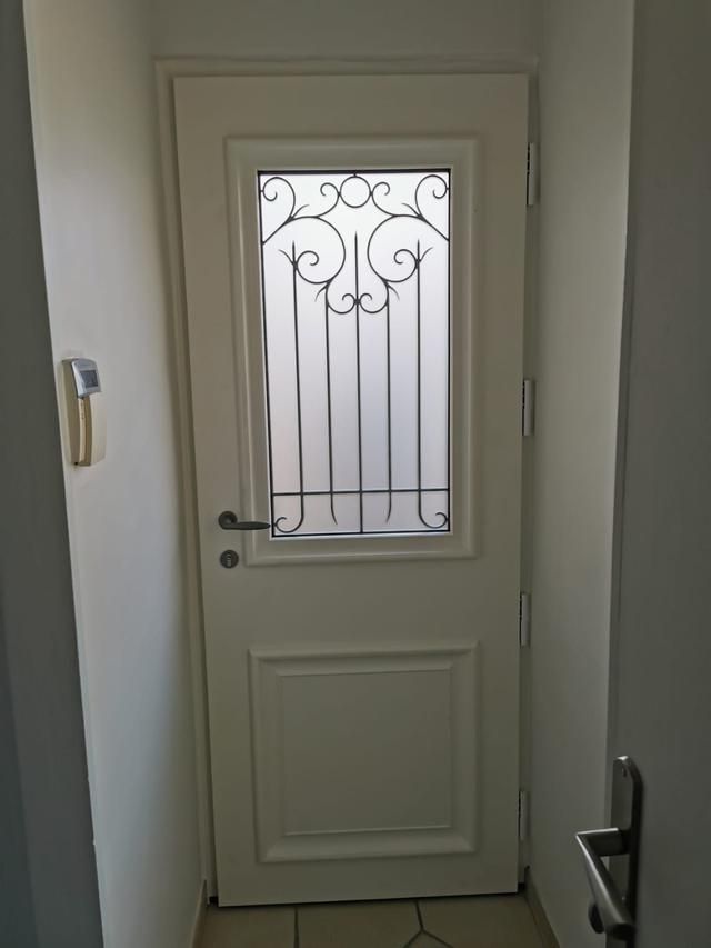 Porte blanche avec un carreau de verre à motif