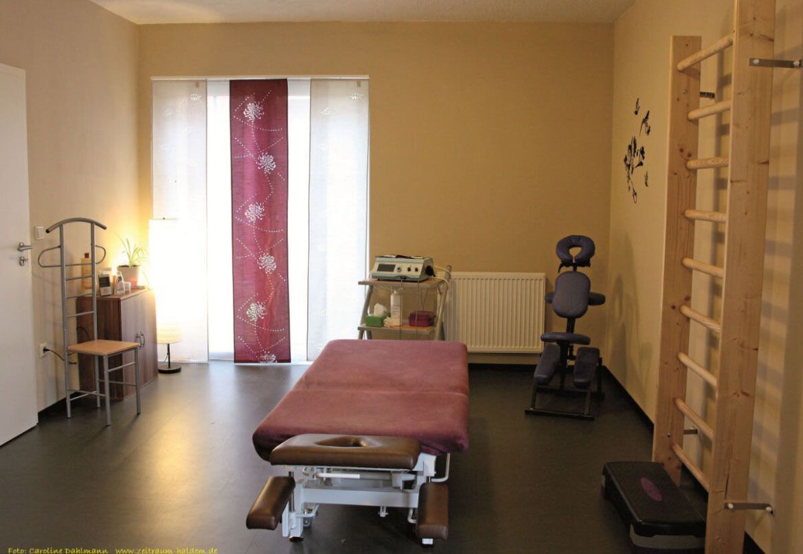 In der Mitte des Raumes steht ein Massagetisch.