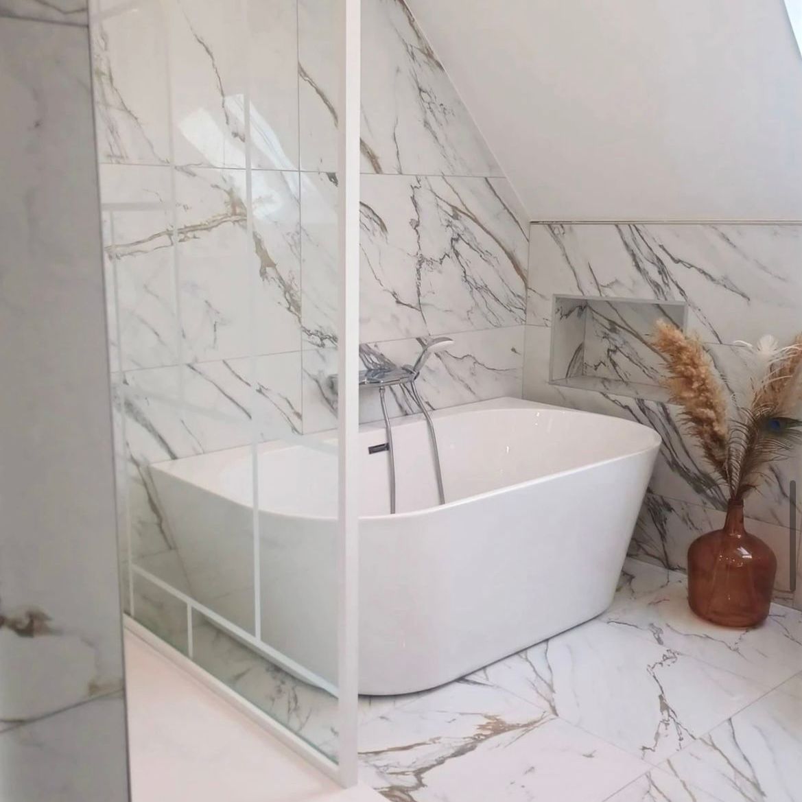 Salle de bains en marbre avec une baignoire sous pente