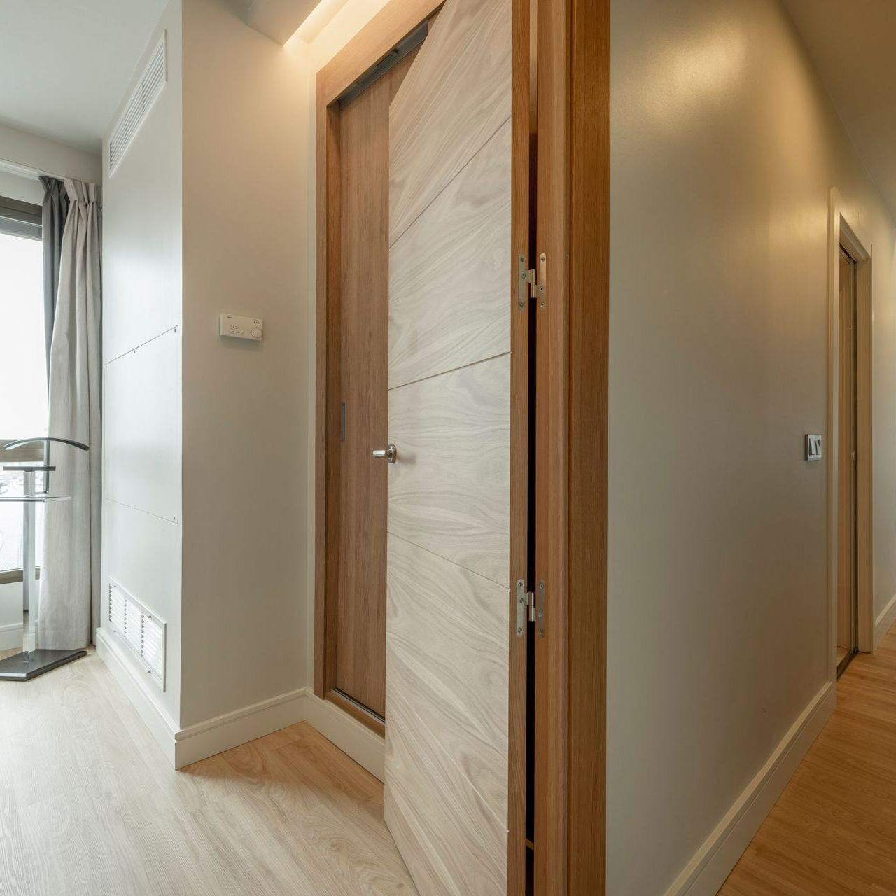Couloir d'une maison avec une porte en bois ouverte