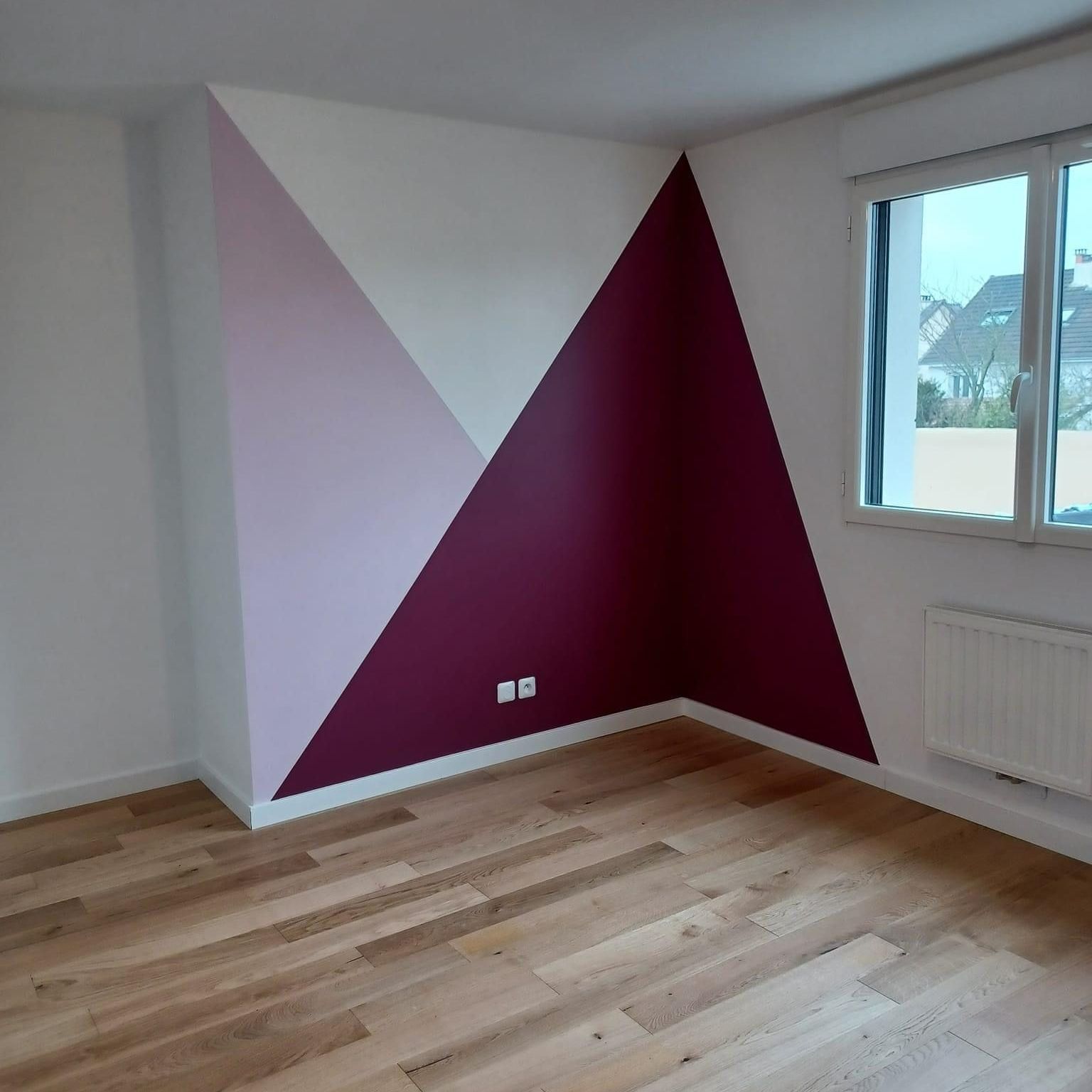 Peinture murale géométrique avec un triangle couleur prune et un autre rose