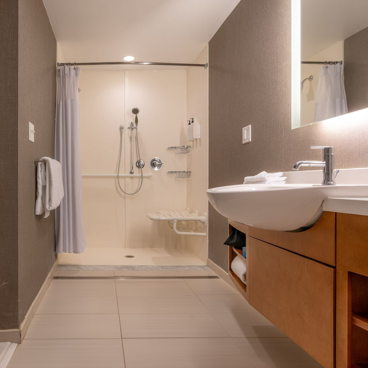 Salle de bains avec une douche adaptée aux PMR