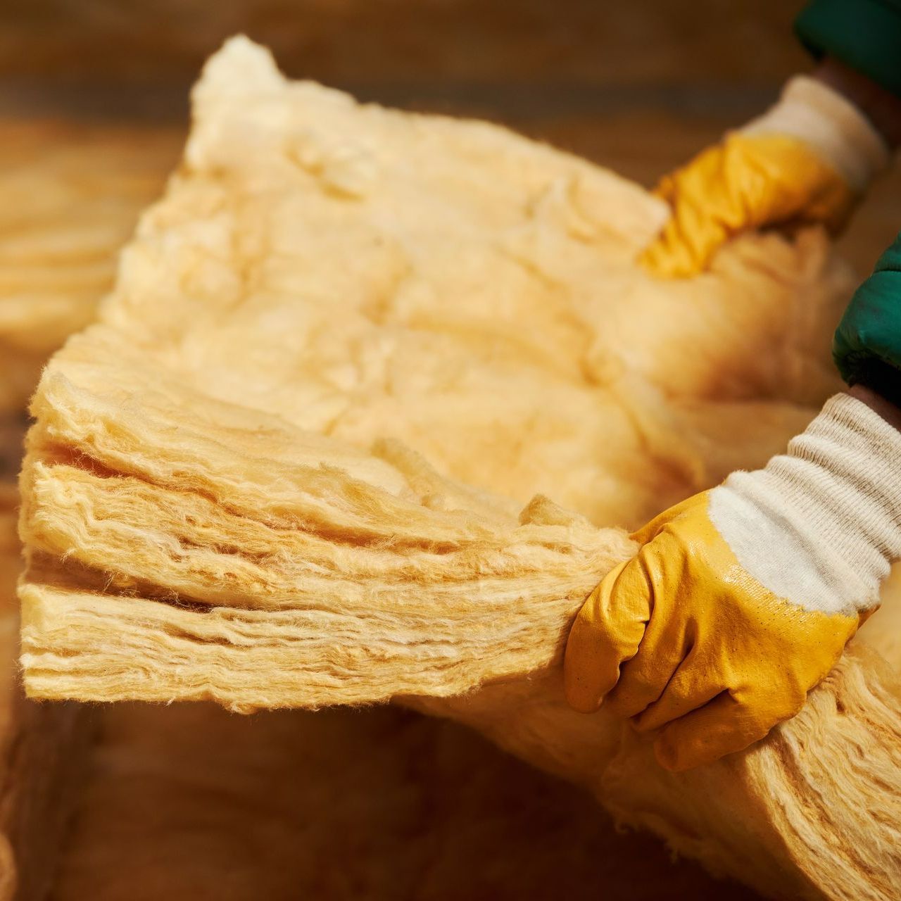 Professionnel avec des gants qui tient une plaque d'isolant