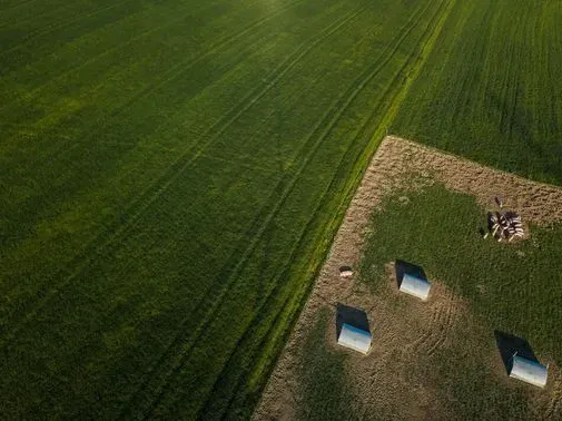 Una vista aérea de un campo verde con tiendas de campaña en el medio.