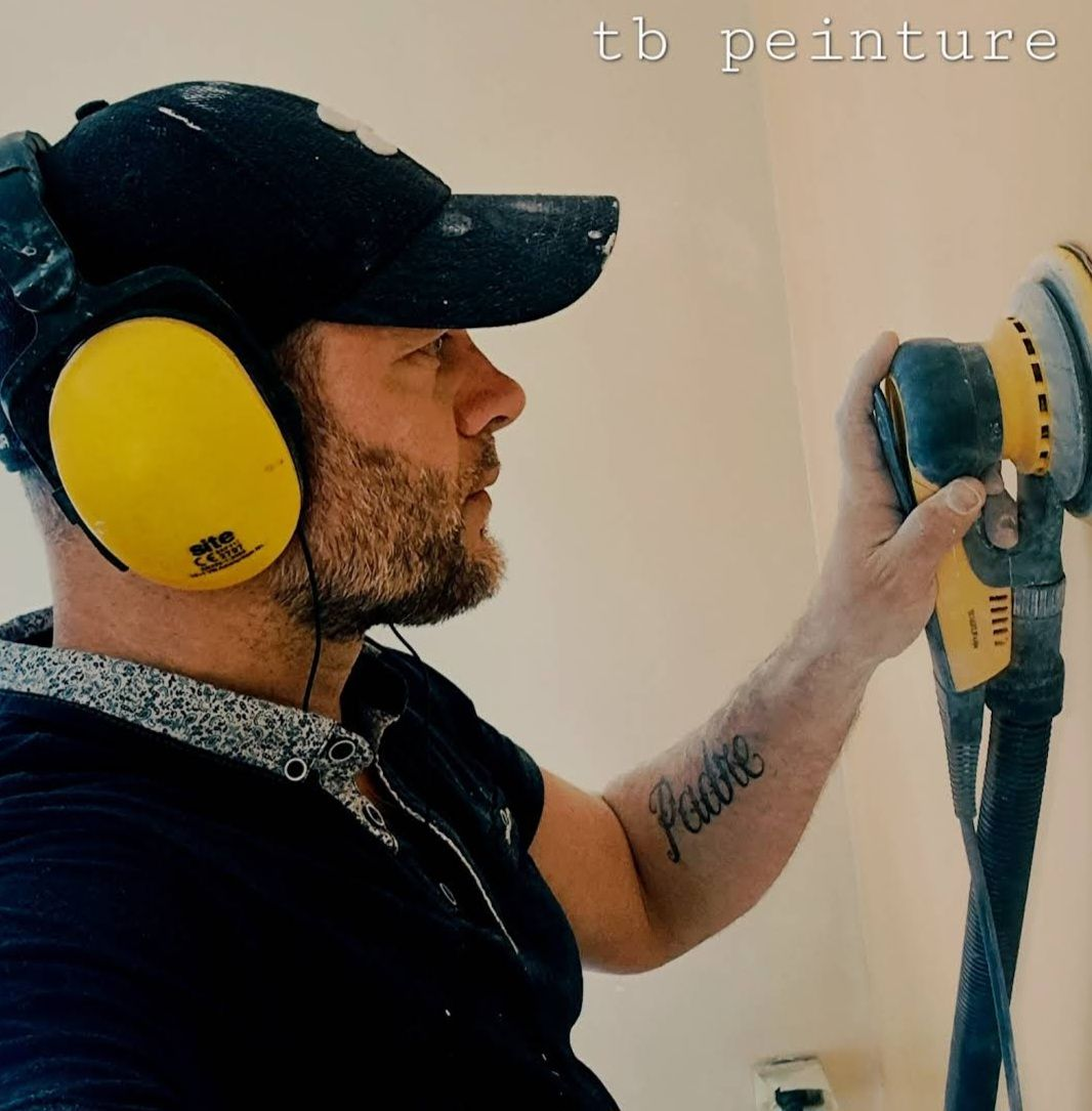 Un meuble et des fauteuils devant un mur peint en marron