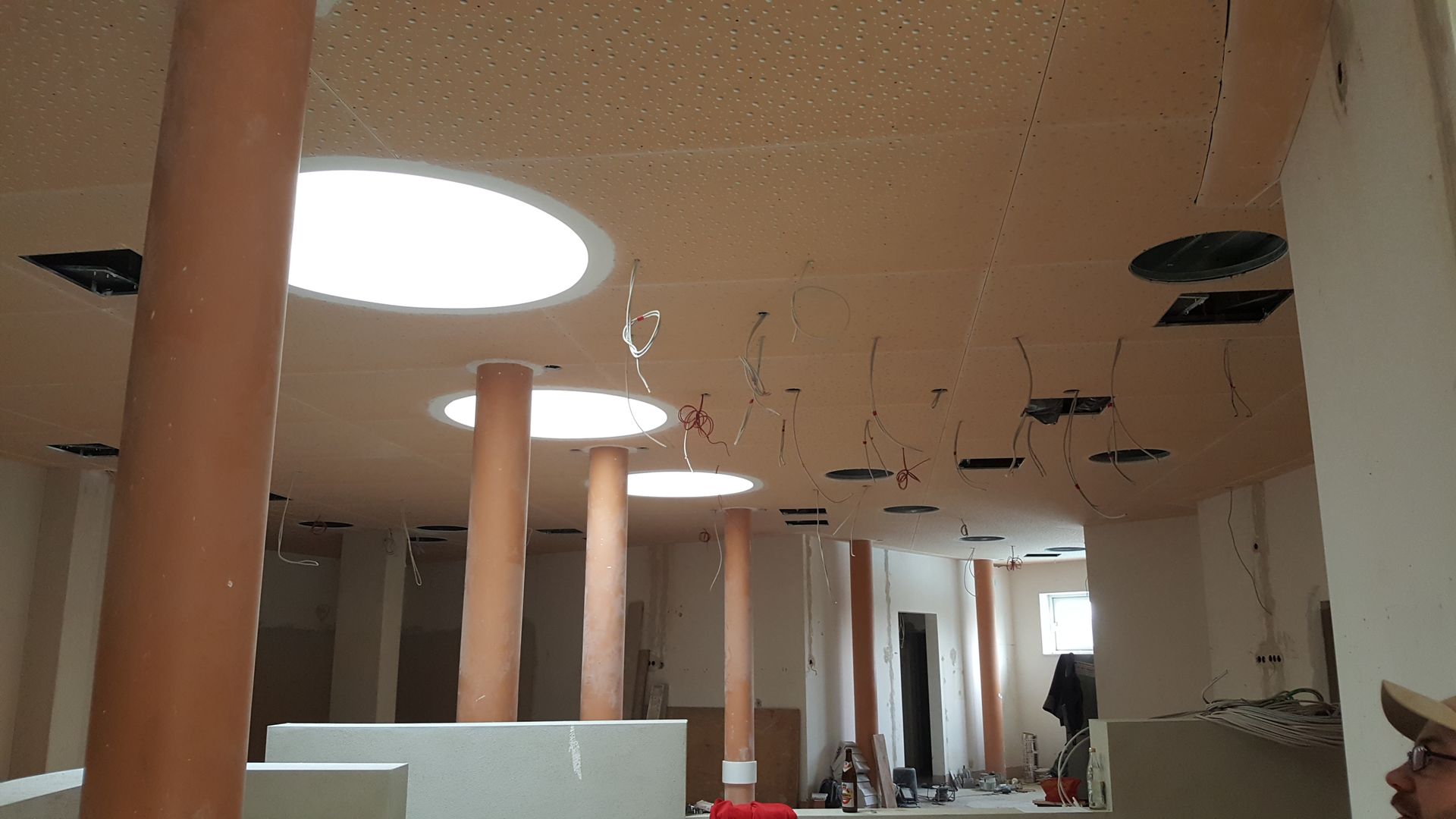 Innenbereich eines Thermalbads mit geschwungener Decke, runden Oberlichtern und modernem Innenausbau.