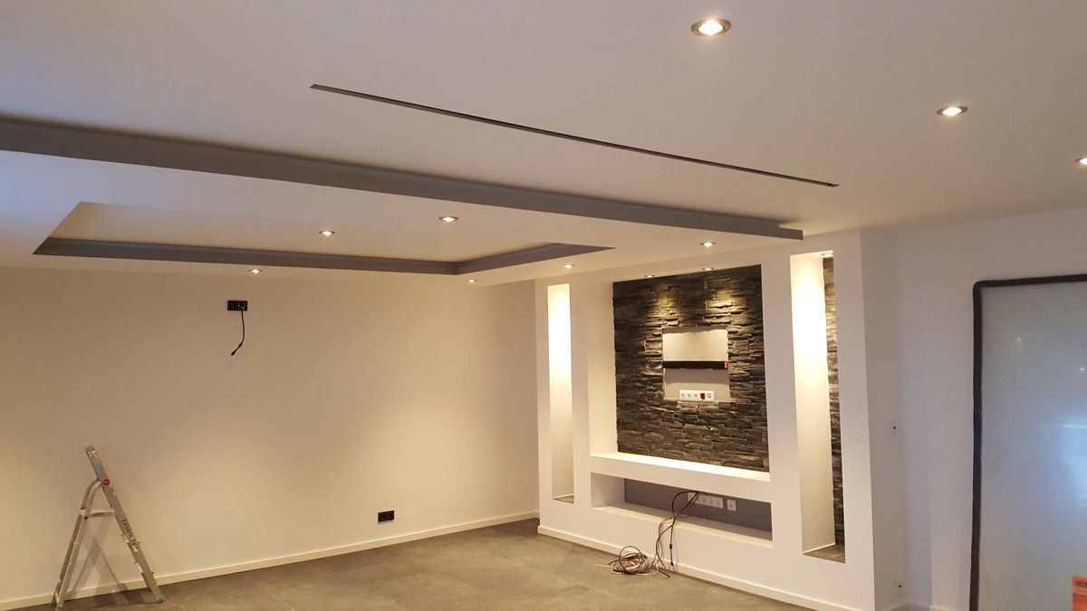 Modern gestalteter Innenraum mit indirekter Deckenbeleuchtung, Holzverkleidungen und dekorativem Wandbild.