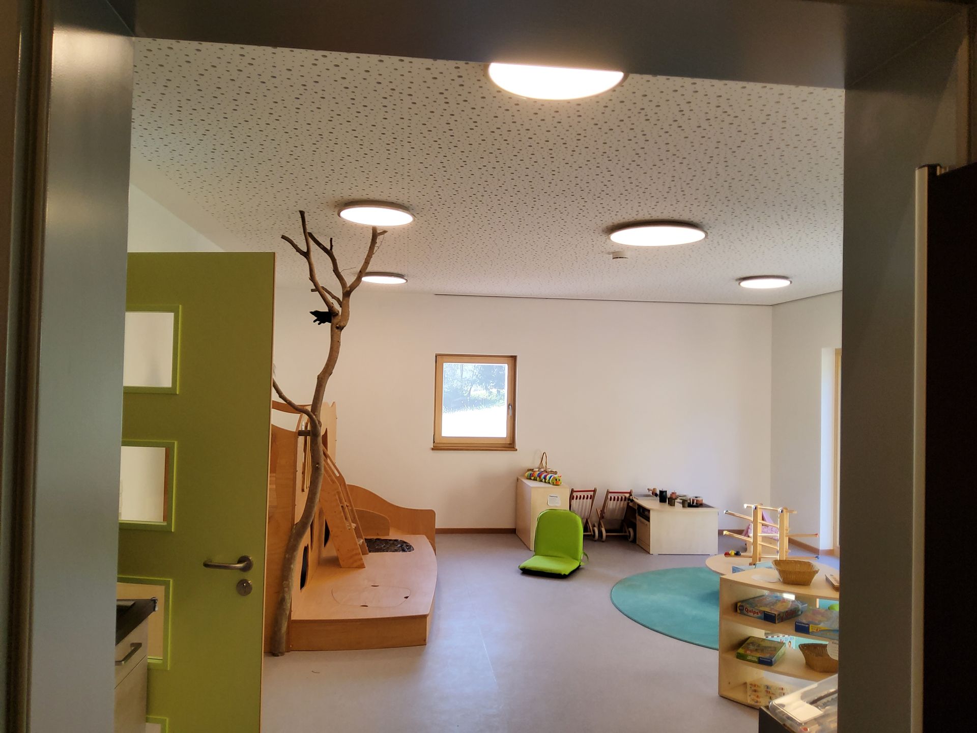 Gruppenraum mit Spielteppich und Kletterelementen im Kindergarten Freyung
