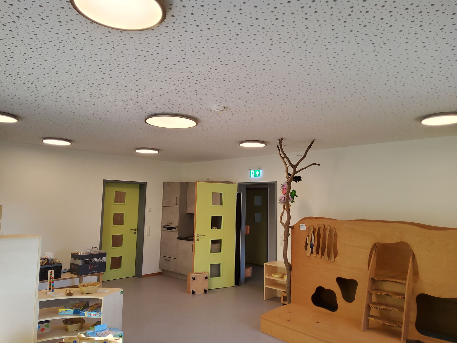 Spiel- und Bewegungsbereich mit Holzstruktur und Spielmaterial im Kindergarten Freyung