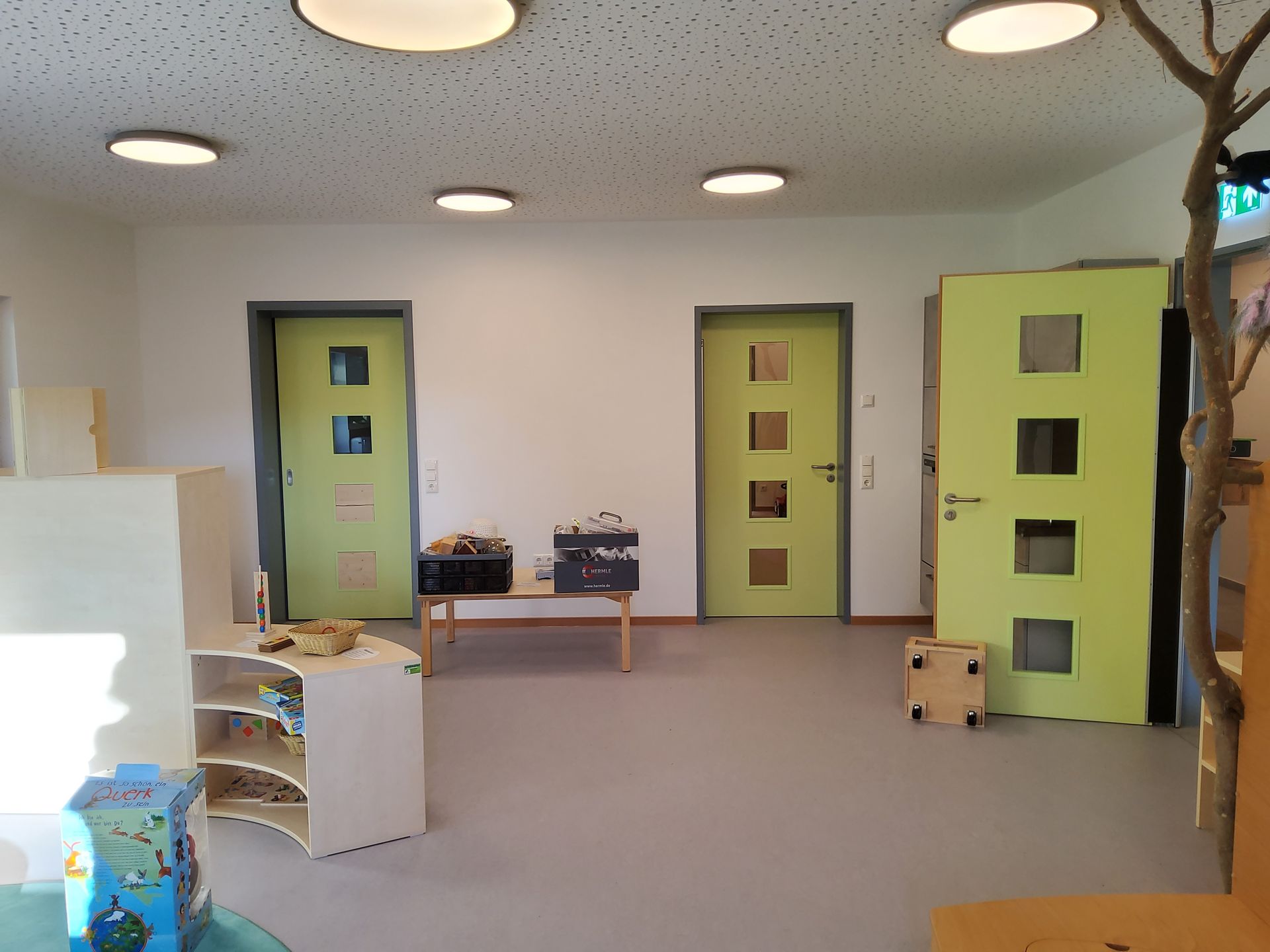 Spielbereich mit Kinderküche und grünen Türen im Kindergarten Freyung