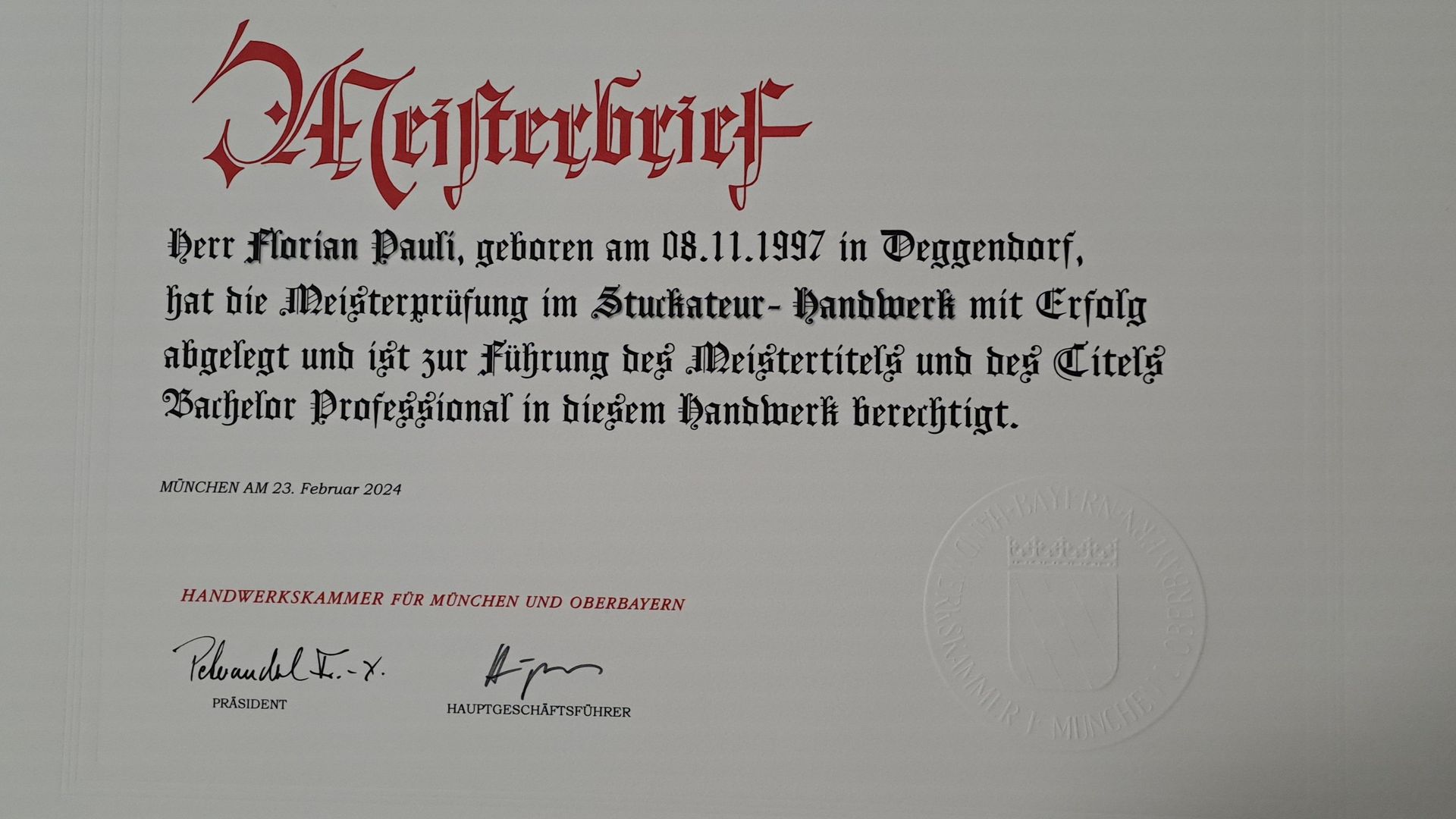 Nahaufnahme eines traditionellen Meisterbriefs mit Text und Siegel.