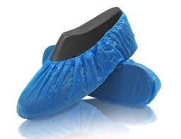 Un par de cubiertas de zapatos azules colocadas una encima de otra sobre una superficie blanca.