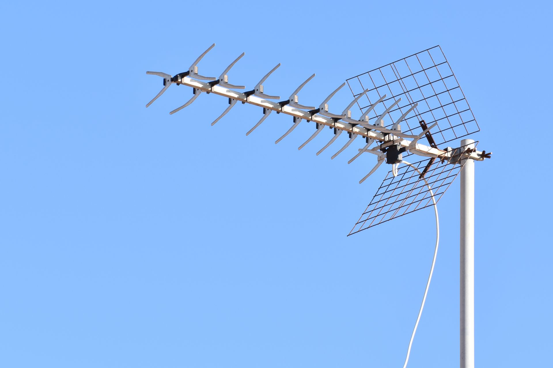 Une antenne de télévision argentée fixée sur un mât.