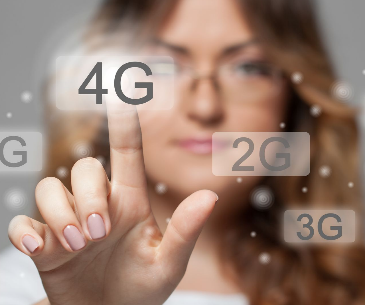 Une femme touche un écran transparent affichant des icônes 4G, 2G et 3G.