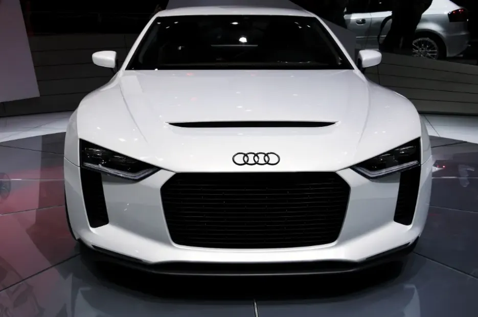 Vista frontal de un Audi deportivo blanco expuesto en un salón del automóvil.