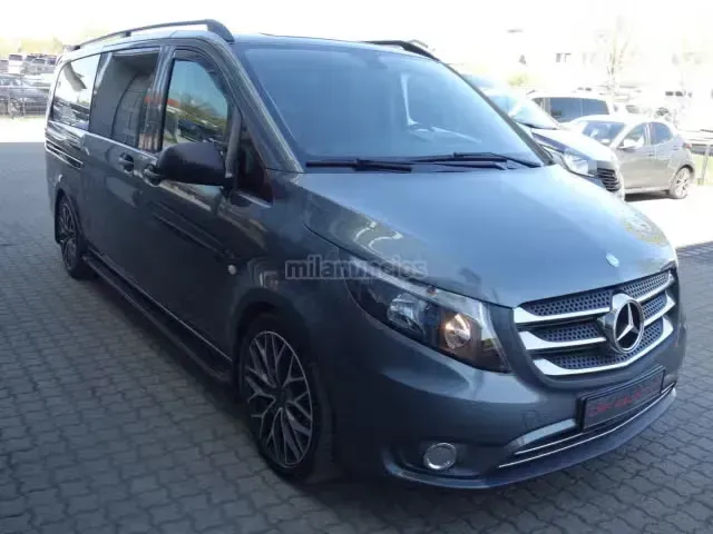 Furgoneta Mercedes gris oscuro aparcada al aire libre en el estacionamiento de un concesionario.