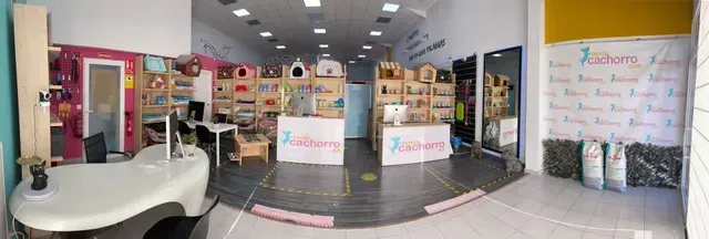 Interior de una tienda de mascotas con exhibiciones de mercancía y un mostrador de recepción.