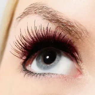 Un primer plano del ojo de una mujer con pestañas largas.