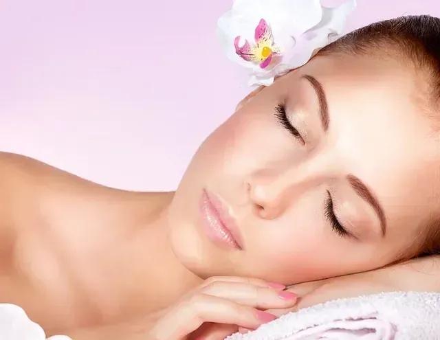 Una mujer está durmiendo con una flor en el pelo.