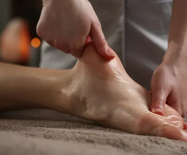 Una mujer está recibiendo un masaje de pies en un spa.
