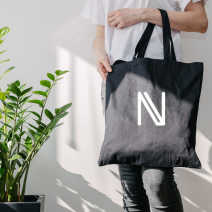 Una persona sostiene una bolsa negra con la letra n.