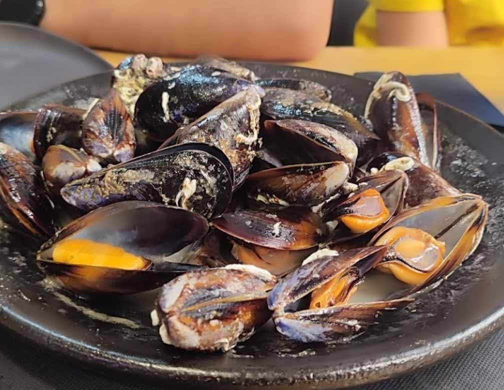 Un primer plano de un plato de mejillones en una mesa.