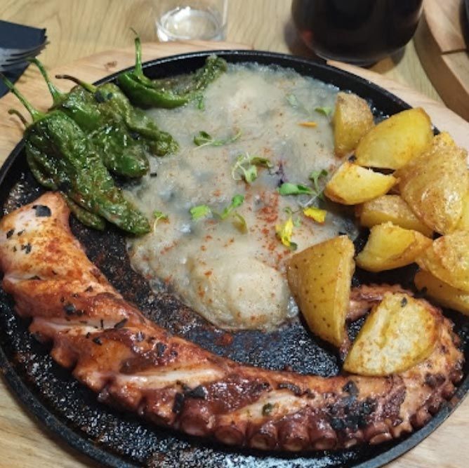 Un plato de comida con patatas y pimientos en una mesa.