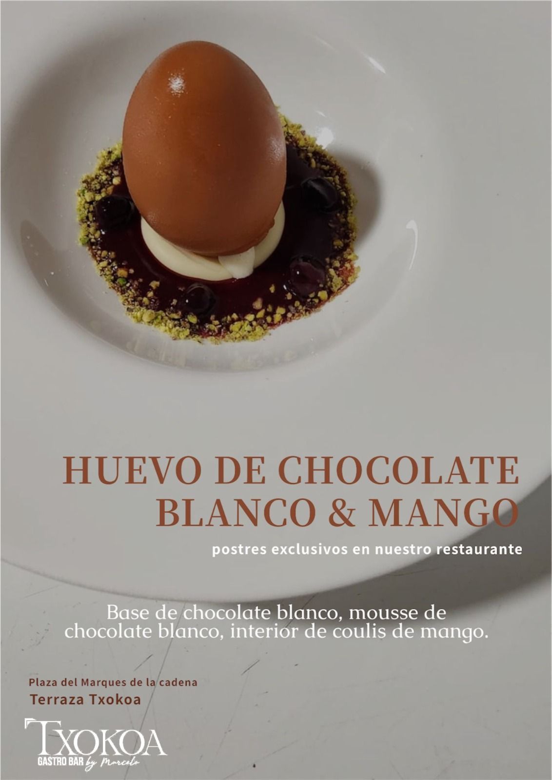 Postre: huevo de chocolate blanco sobre salsa oscura, coulis de mango, guarnición verde, plato blanco, logo Ixokoa.