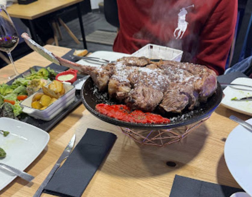 Un gran trozo de carne está en un plato sobre una mesa.