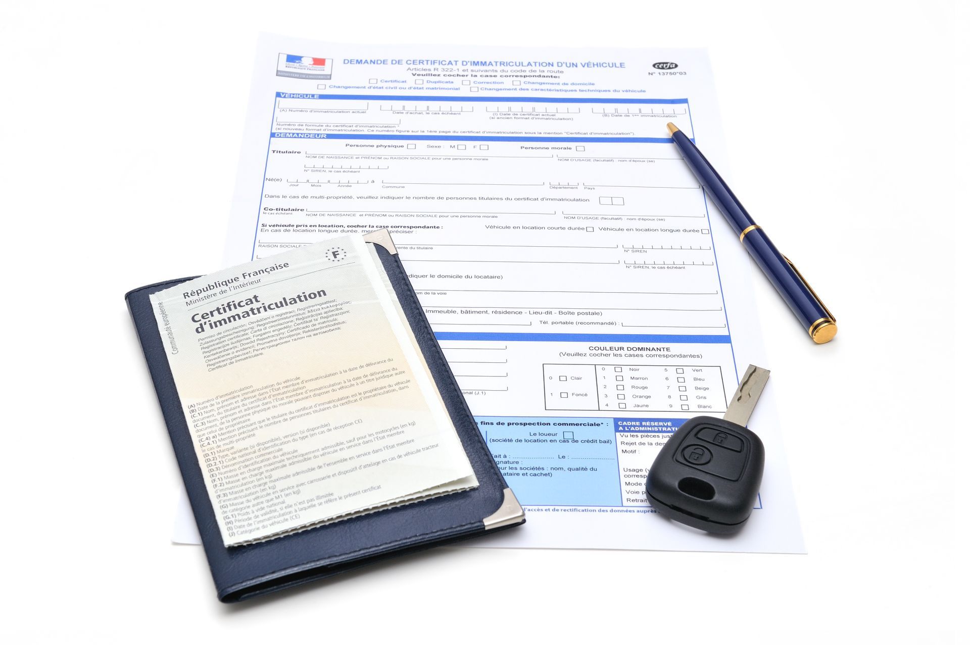 Demande de certificat d'immatriculation, carte grise, clé de voiture et stylo sur fond blanc.