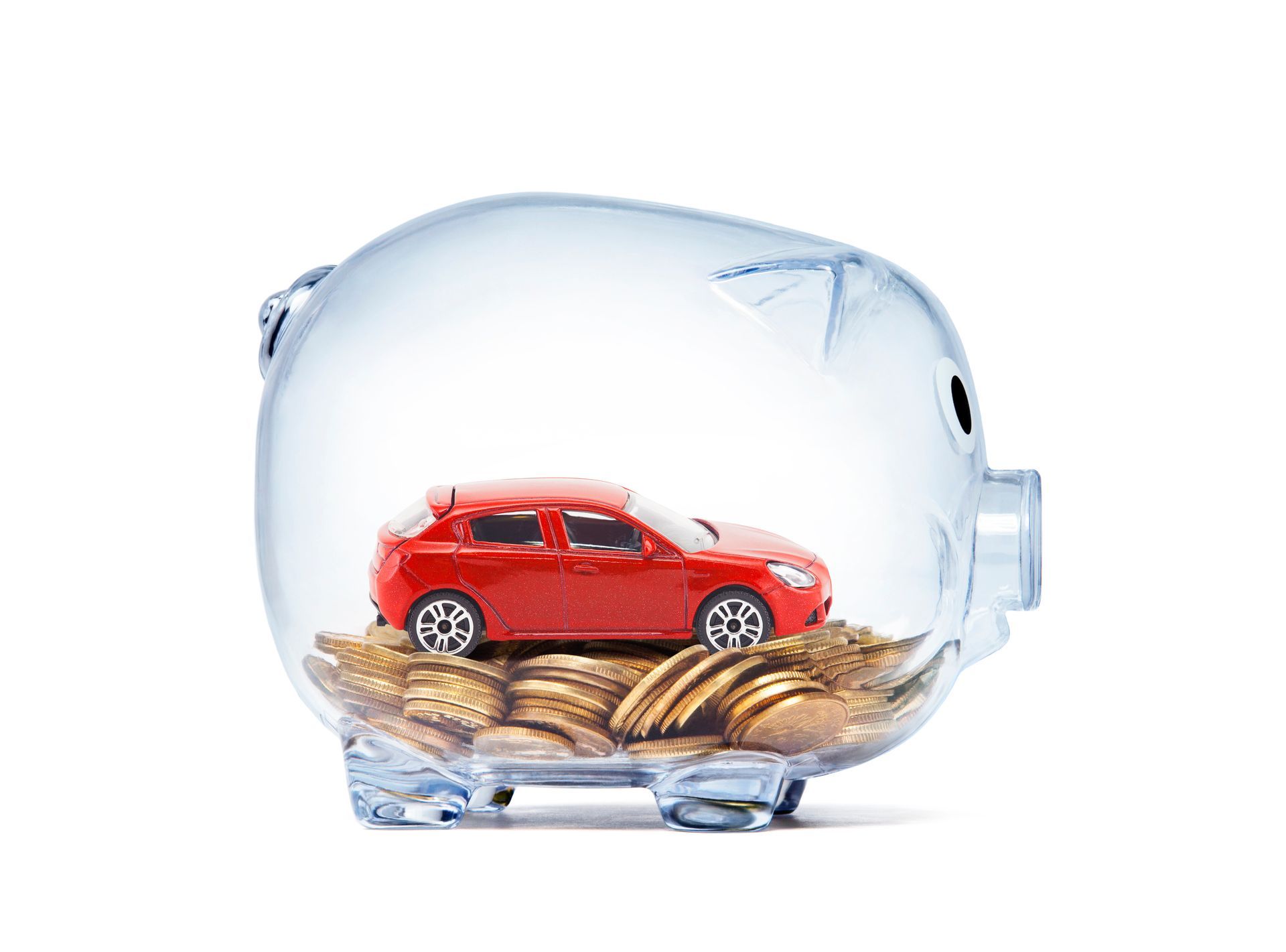 Voiture miniature rouge et pièces de monnaie à l'intérieur d'une tirelire en verre.