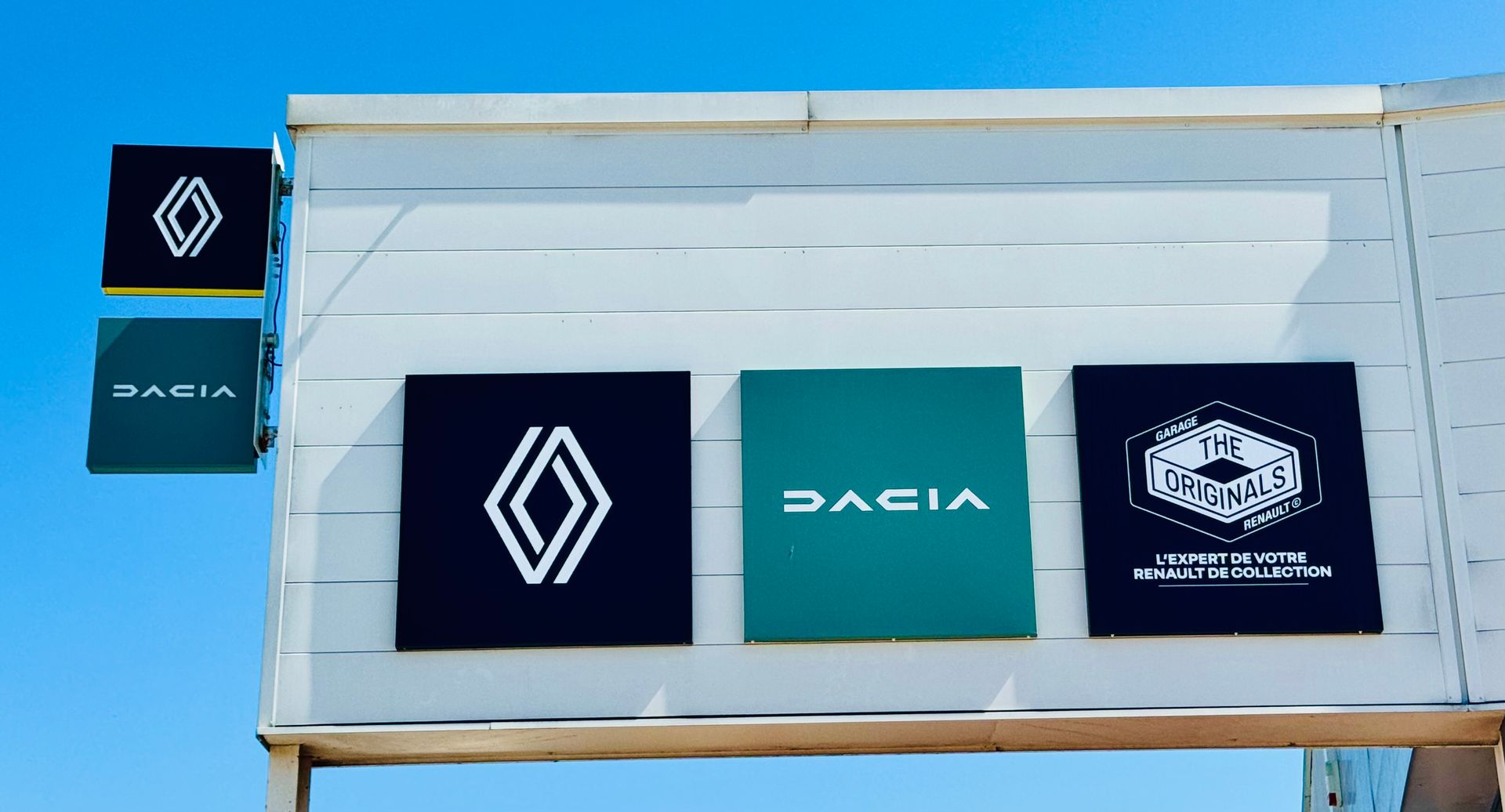 Panneaux publicitaires Renault et Dacia sur la façade d'une concession.