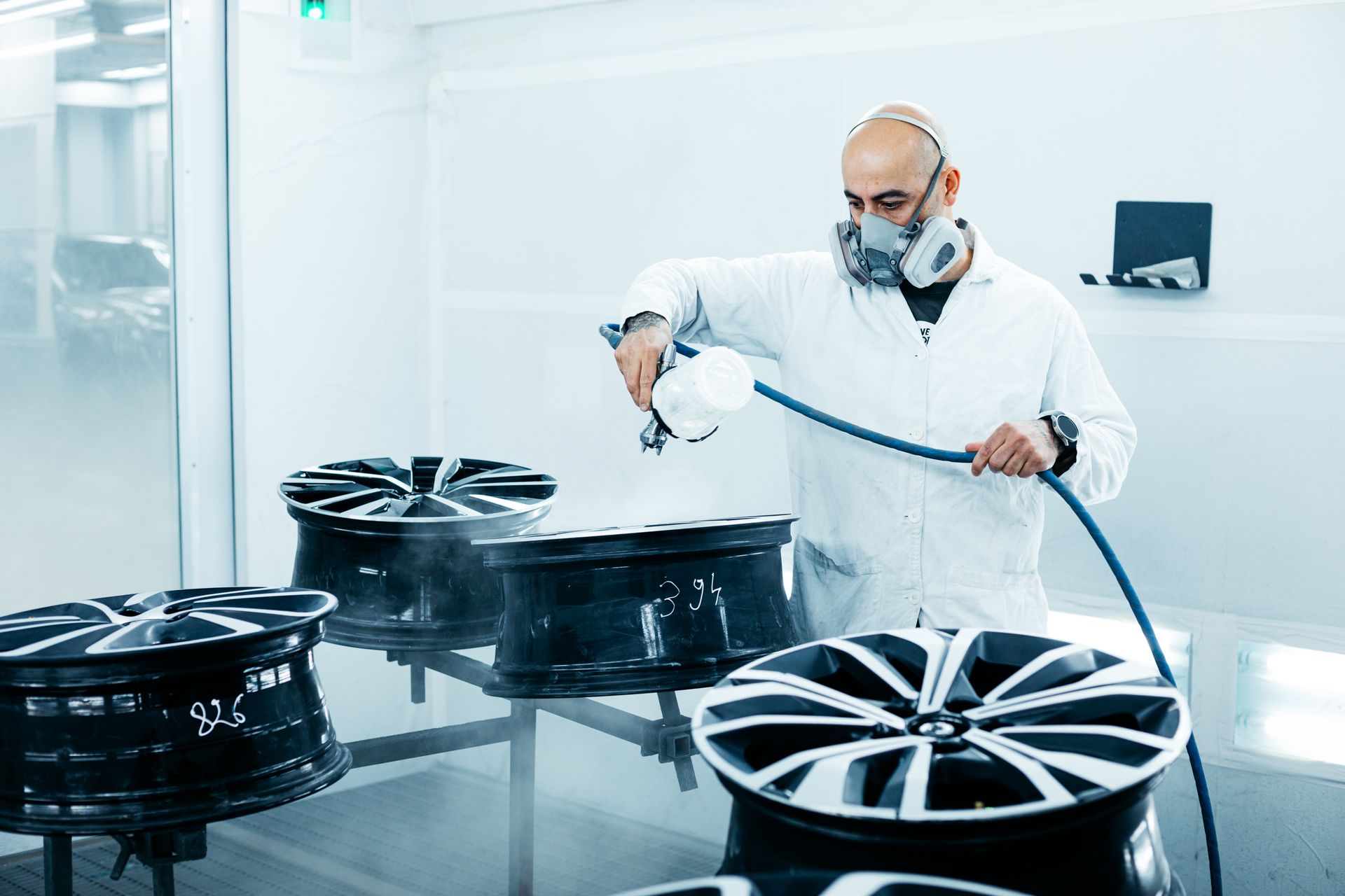 Un homme est en train de peindre des jantes de voiture