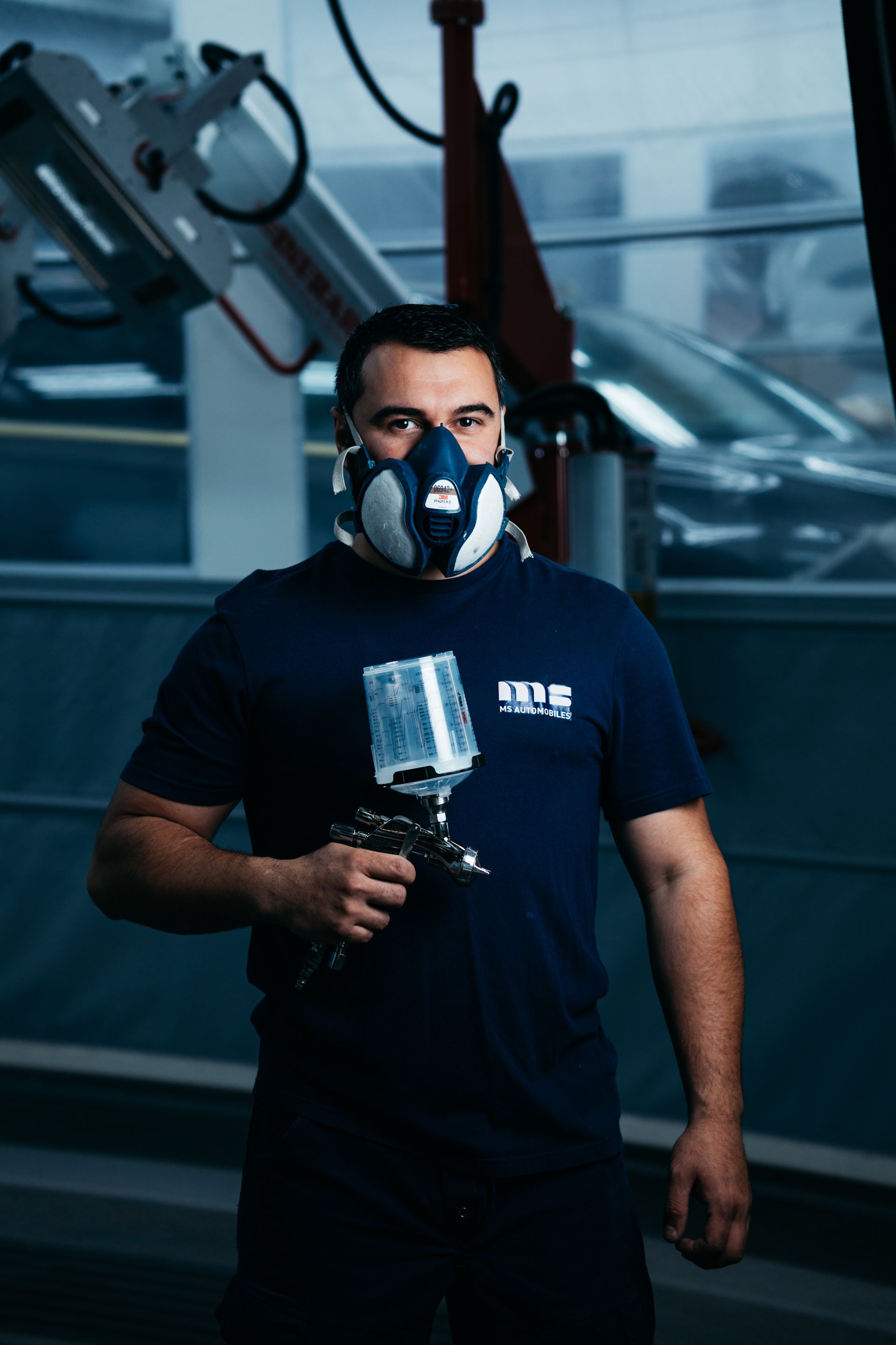 Photo portrait d'un mécanicien de l'entreprise, un pistolet de peinture à la main