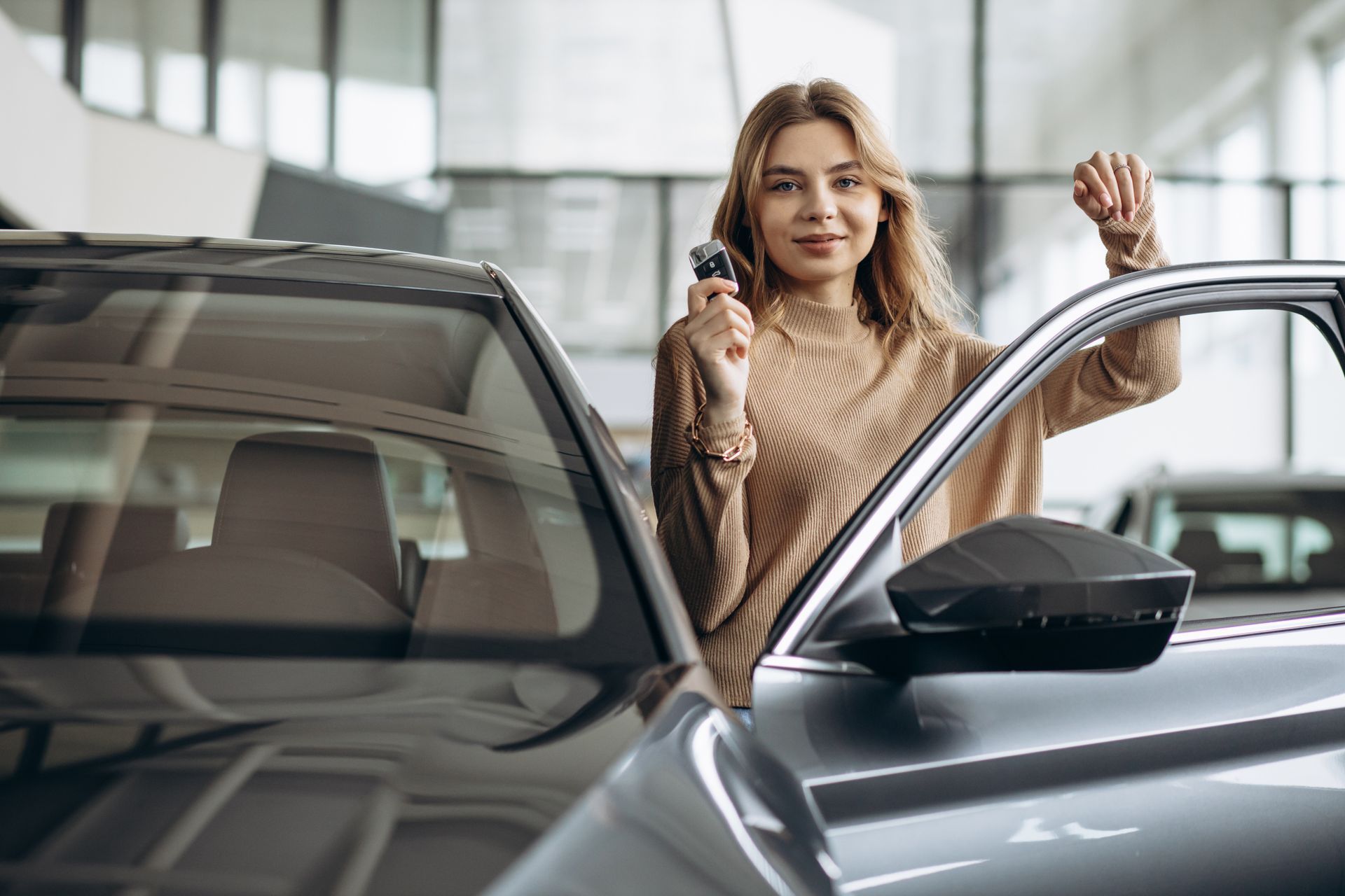 Jeune femme souriante avec ses clés de voiture en main