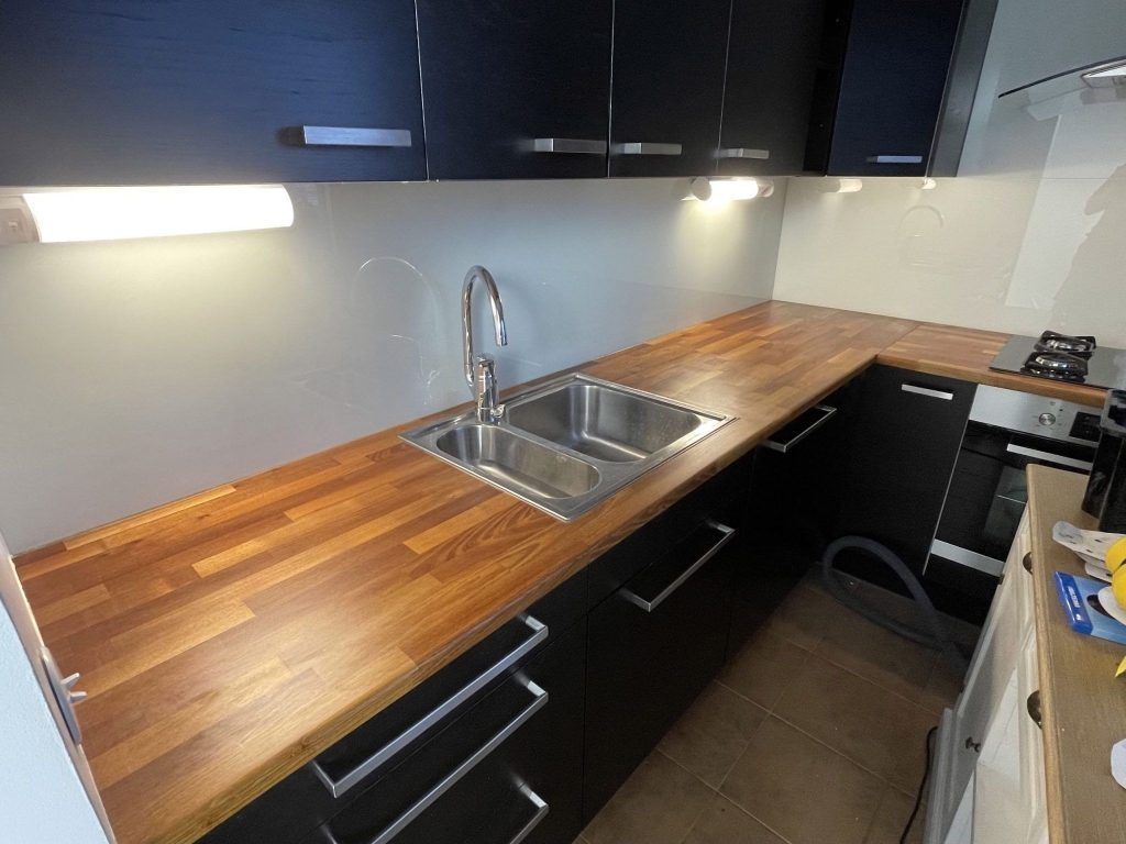 Tyylikäs ja ergonominen keittiö, jossa on uudet työtasot ja valaistus.