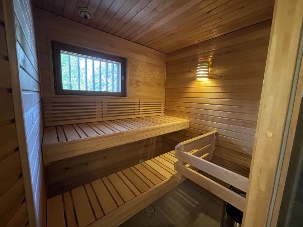 Saunaremontti, jossa on uudet tervaleppälauteet ja tyylikäs valaistus.