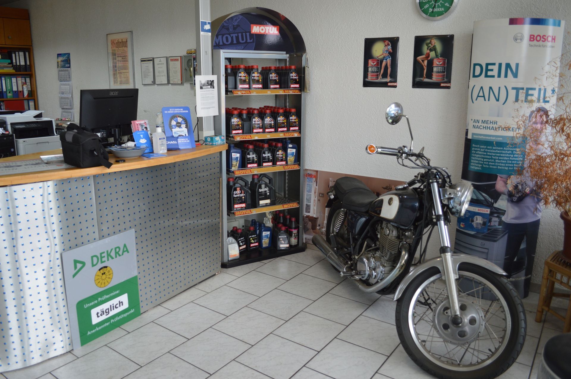Empfangs- und Wartebereich der Werkstatt mit Verkaufstheke, Fahrrad und Präsentationsregal.