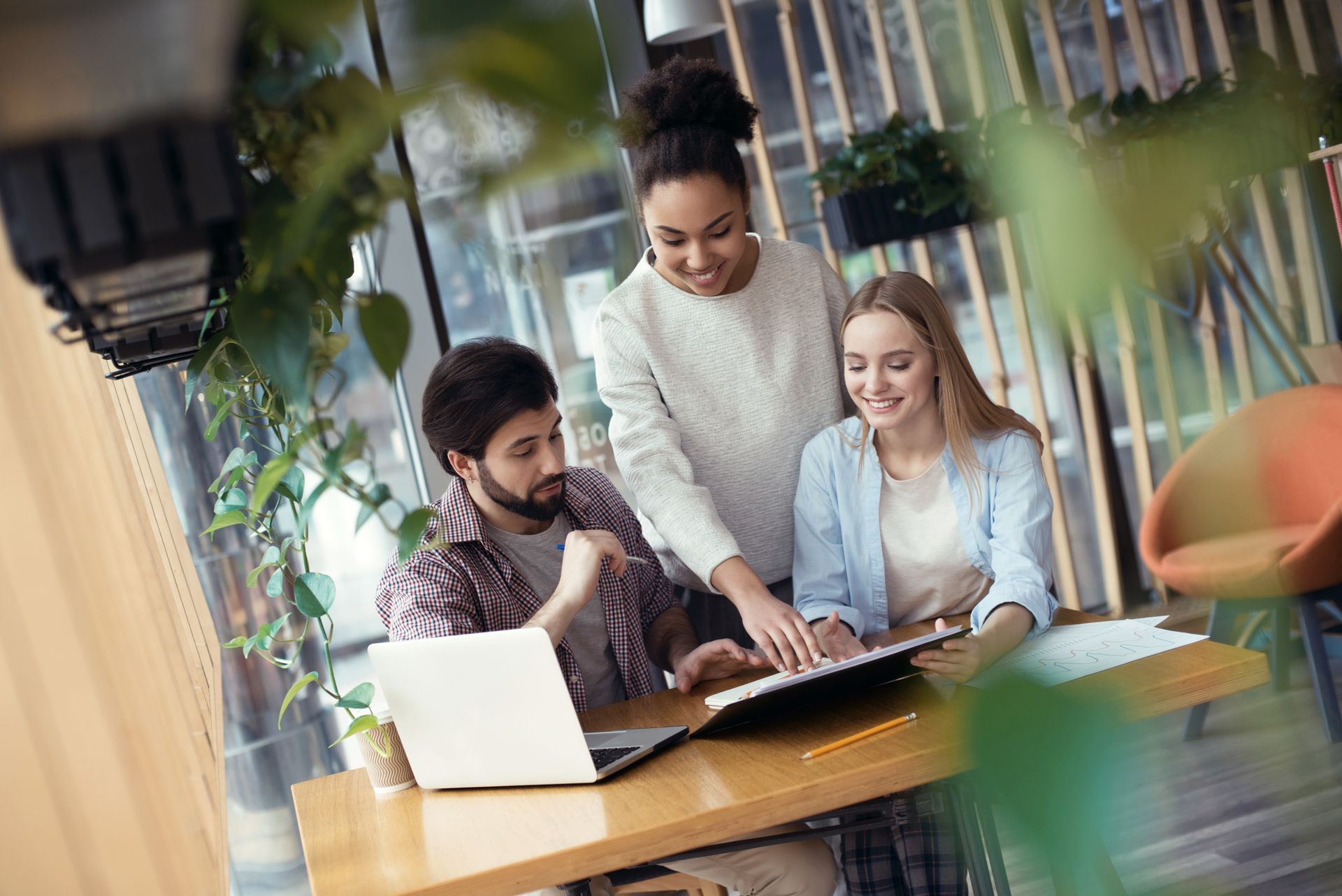 Dans un bureau moderne et lumineux, trois collègues font du coworking.