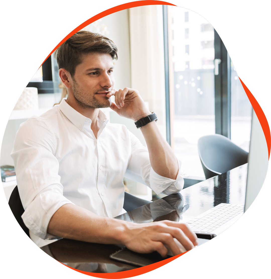 Un jeune homme assis devant son ordinateur