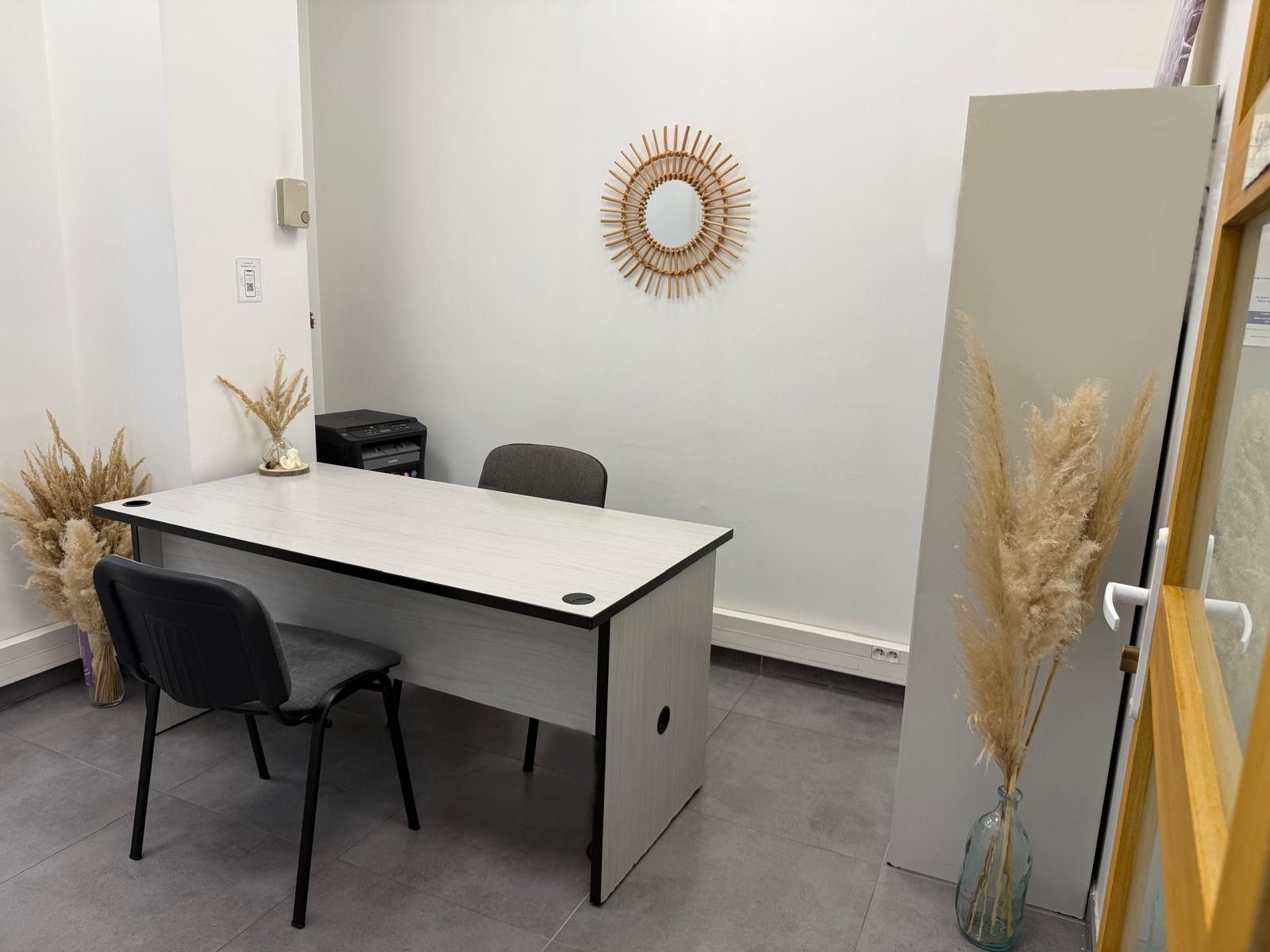 Un homme devant son ordinateur regarde son téléphone portable