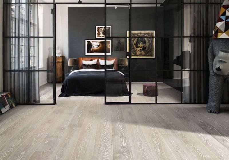 Un dormitorio con una puerta corrediza de vidrio entre el dormitorio y la sala de estar.